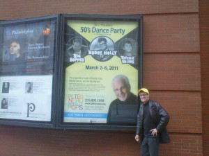 John in front of poster